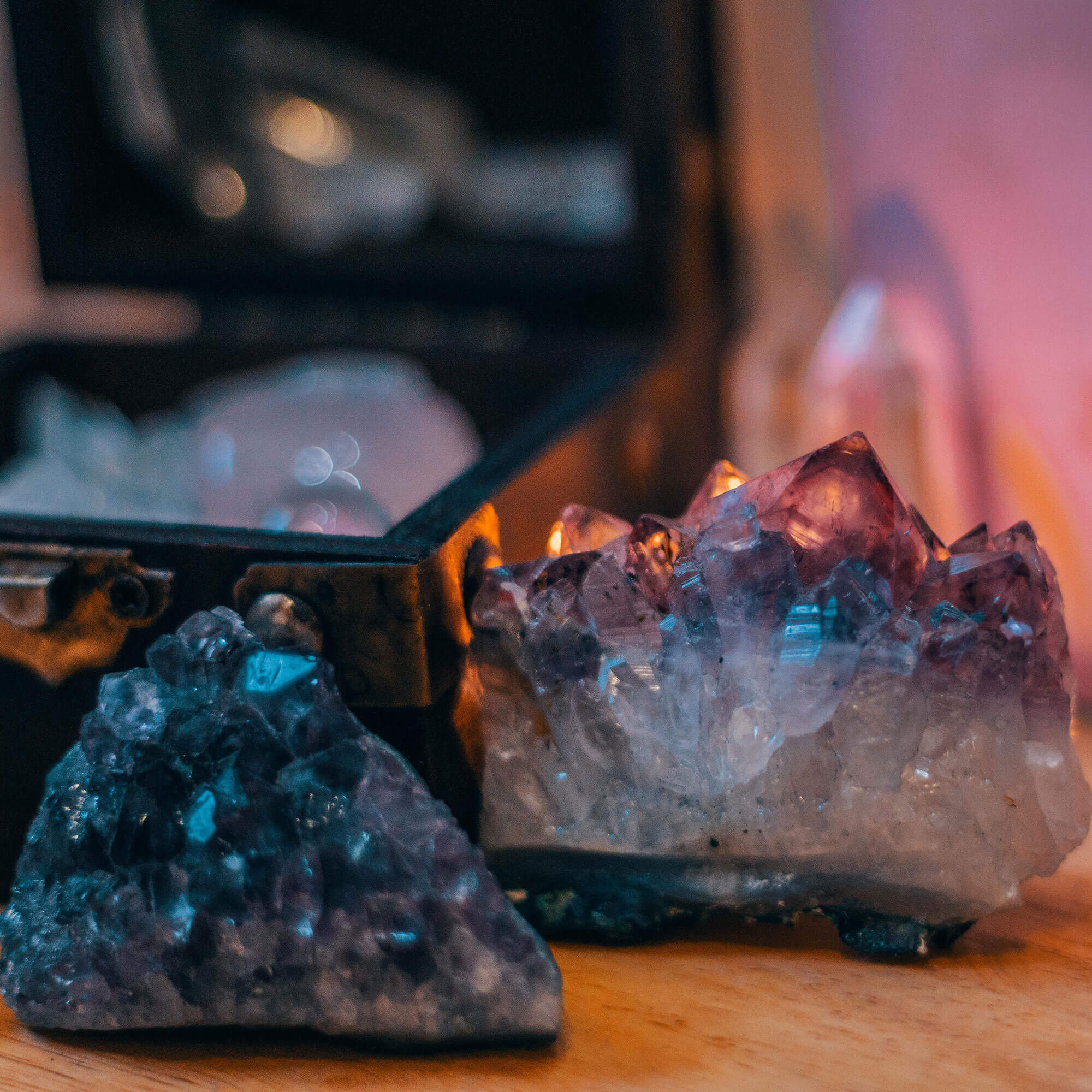 Two crystal formations on a wooden surface with a blurred background